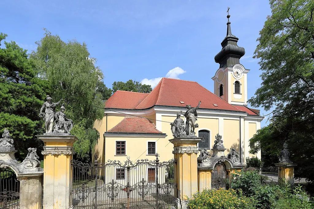 Westansicht der röm.-kath. Pfarrkirche hl. Andreas in der niederösterreichischen Marktgemeinde Ladendorf und davor die Toranlage des Schlosses.Der spätbarocke Sakralbau mit Fassadenturm wurde 1766 nach Plänen von Peter Mollner errichtet. Davor das Hauptportal des Schlosses aus dem 2. Viertel des 18. Jahrhunderts.