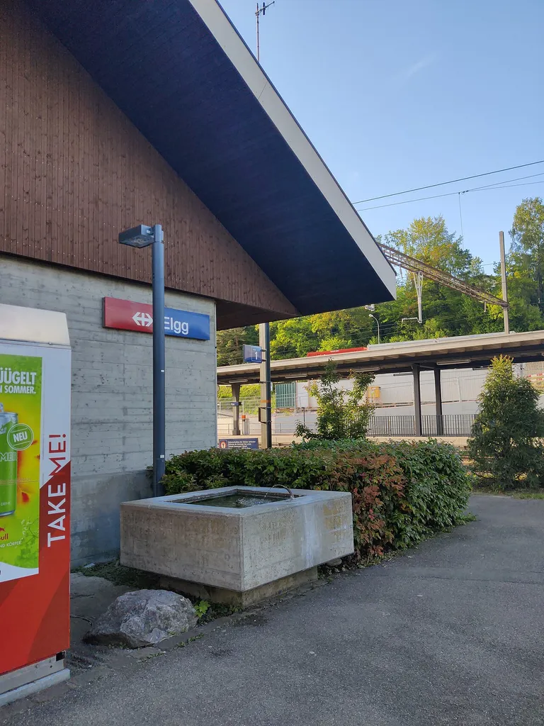 Detail view of the station building at Elgg ZH railway station, designed by Max Vogt. The building's distinct gabled roof is very unusual for Vogt's railway stations. Today, the station building houses a restaurant and an apartment. On the. eastern side of the building, there is a station square with a small concrete fountain which is a distinct architectural element of Vogt employed at many of his stations.