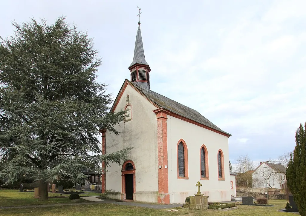 54634 Matzen, obere Donatusstraße. Saalbau, spätbarocke und neugotische Motive, 1816; zum Kriegerdenkmal erweitertes neugotisches Friedhofskreuz, 1887. Aufnahme von 2018.