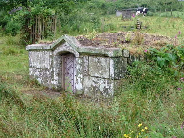 Holy Well, Davidstow. Restored in the 19c by a Michael Williams (whose initials are carved above the door) The water rises into a deep pool inside. The water is reputed to never run dry although for the last 60 years it has been pumped away to a nearby cheese factory.