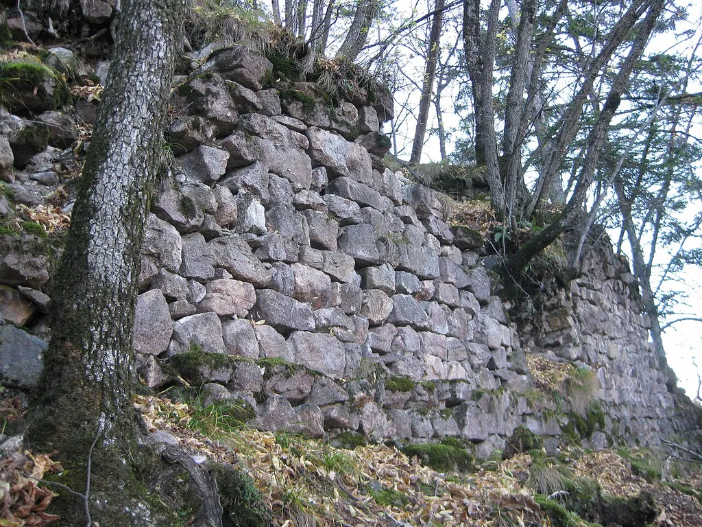 Mauerreste der Burgruine Andrian. Die Anlage befindet sich versteckt im Wald auf einem Geländesporn oberhalb von Wolfsthurn.