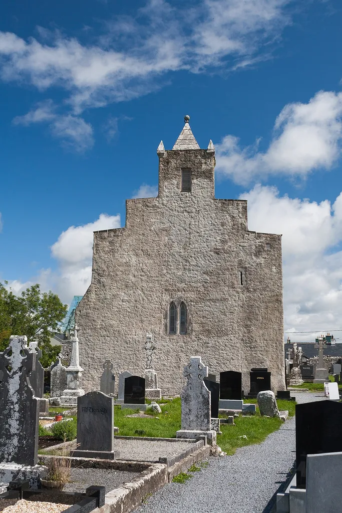West gable and tower of Kilfenora Cathedral. Many reviews dislike this view of the cathedral. The RSAI wrote in 1900: “The cathedral is, externally, an ugly building, with an uglier tower, suggestive of a heap of shapeless boxes”. They, in turn, quoted from the “Handbook to Lisdoonvarna” by Philip Dwyer published in 1876 which reads: “The attempt at a tower is conspicuously mean and hideous. A pile of emigrants' luggage, with a rabbit-hutch or bird-cage overhead, would look equally imposing.” See p. 395 in: “Proceedings”. 1900. “Proceedings”. The Journal of the Royal Society of Antiquaries of Ireland 10 (4). Royal Society of Antiquaries of Ireland: 388–450. https://www.jstor.org/stable/25507107.