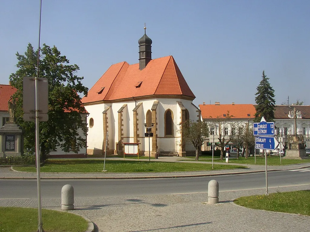 Church of Nativity of St John the Baptist in centre of Starý Plzenec, Plzeň-City District, Czech Republic. A view from the southeast, from town hall. The church of Romanesque origin from 11th century was later rebuilt in Gothic style. Marian Column from 1721 surrounded with statues of SS Joseph, Wenceslas, Ludmilla and Barbara can be seen on the right edge, WWI memorial on the left edge.