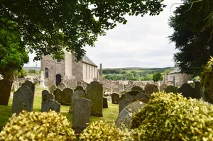 Bewcastle Roman fort, high cross shaft in St Cuthbert's churchyard, and Bew Castle medieval shell keep castle