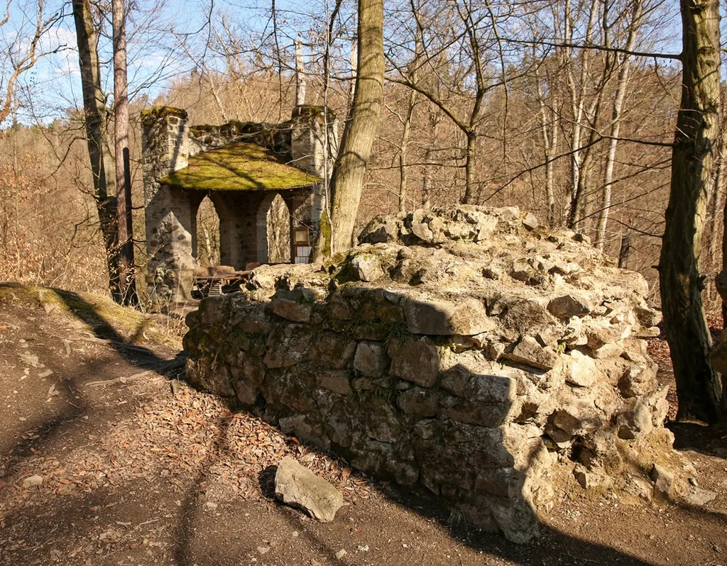 Mauerreste der ehemaligen Burg Schwarzberg (Goßdorfer Raubschloss) bei Goßdorf in der Sächsischen Schweiz. Im Hintergrund ist eine im 19. Jahrhundert errichtete künstliche Ruine zu sehen.