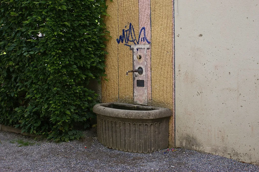 Brunnen Spielplatz Gryphenhübeli mit Brunnentrog, aufgemaltem Brunnenstock, sowie Brunnenröhre und Wasserhahn, beides aus Messing.