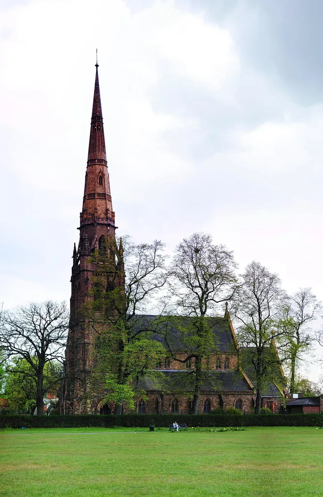 Platt Fields Park, Rusholme, Manchester, with Holy Trinity parish church behind a row of trees. The image is a panorama of about 12 photos, taken at 18mm, stitched with Hugin.
