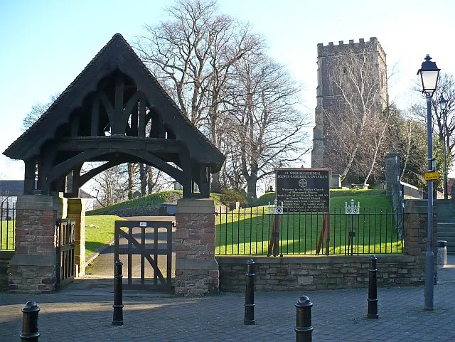 St Woolos Cathedral lychgate and tower The lychgate has two inscriptions. On the left "TO THE GLORY OF GOD THIS LYCHGATE AND WESTERN APPROACH WERE DEDICATED TO THE MEMORY OF DAVID HENRY GRIFFITHS M.A. ARCHDEACON OF MONMOUTH, VICAR OF ST WOOLOS A.D. 1908-1926". On the right "BLESSED IS THE MAN WHOM THOU CHOOSEST AND RECEIVEST UNTO THEE: HE SHALL DWELL IN THY COURTS AND SHALL BE SATISFIED WITH THE PLEASURES OF THY HOUSE".