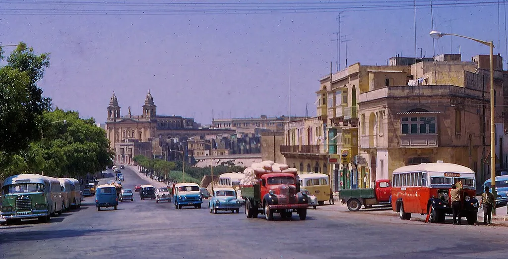 Marsa is located on the western limits if Valletta's Grand Harbour. Back in 1967, the routes and destinations of the eccentric but quaint buses in Malta could be discerned by the colour of their brilliantly coloured livery. e.g. the Red Bus, the Green Bus, the Yellow Bus, the Blue Bus.. Many of these much loved workhorses had stripes. Dominating the skyline is the parish Church of the Holy Trinity.