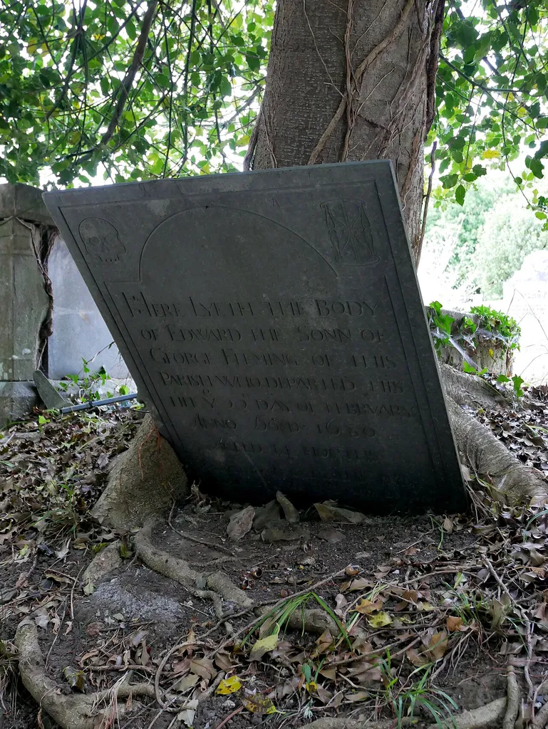 The Fleming Tombstone, dating from the seventeenth century, in the southeast area of the churchyard surrounding the Church of Saint Peter in Fremington, North Devon. This is a photo of listed building number 1107652.