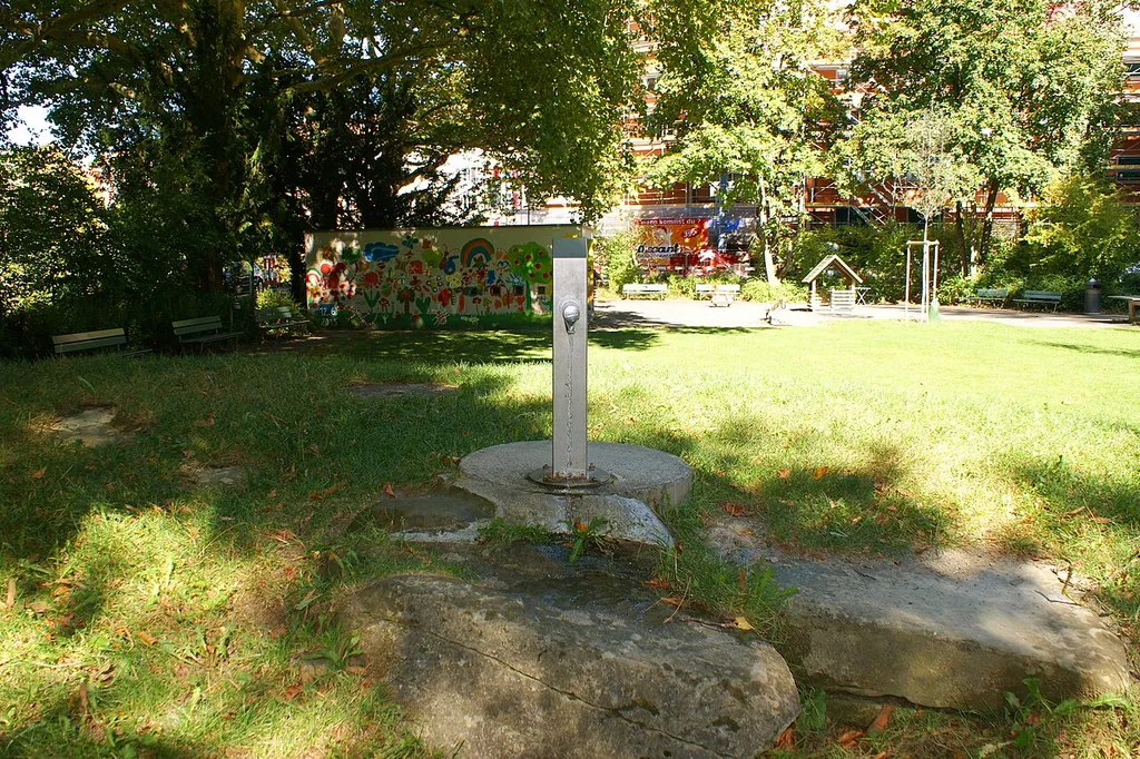 Spielbrunnen Spielplatz Lory mit Gebäude Schlossstrasse 12a im Hintergrund.
