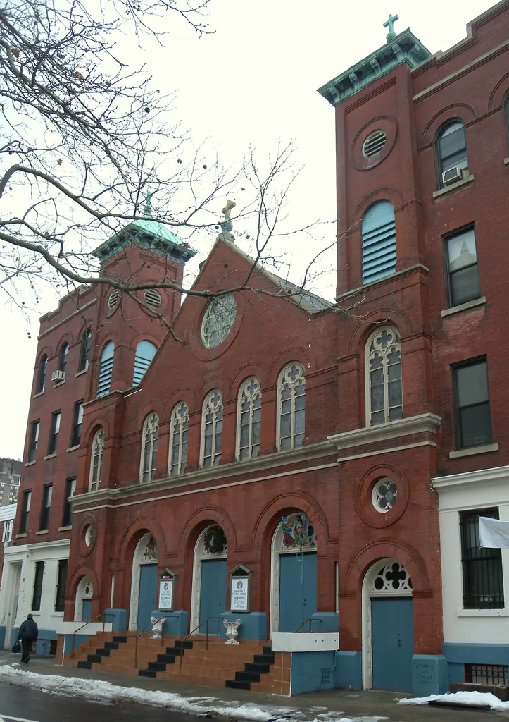 Looking south across East 147th Street at Saint Pius Church on a rainy midday. ZIP 10454.