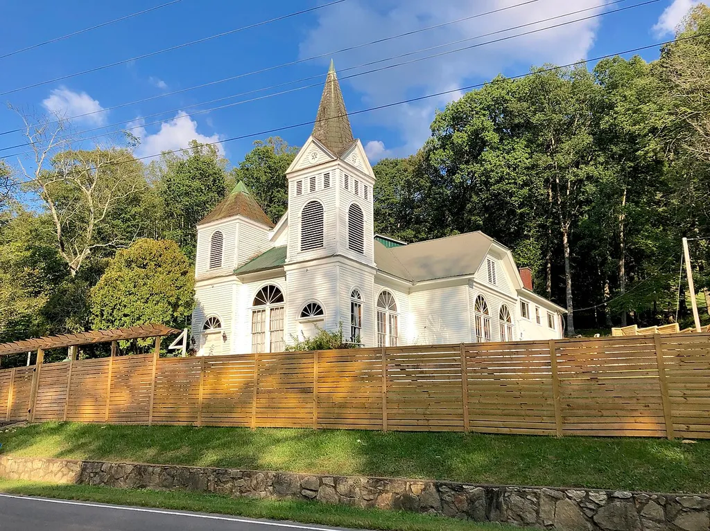 This is the former California Creek Missionary Baptist Church, located in the rural hamlet of California Creek in Madison County, North Carolina. Constructed in 1917, the church was moved to this located on US Highway 23A in 1937, and is listed as a Gothic Revival-style, though it more closely appears to resemble the Romanesque Revival style. The church was sold to private ownership after a new church was built nearby in the 1970s, and was listed on the National Register of Historic Places in 1984.