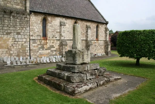 Base and broken shaft of stone cross in St Oswald's parish churchyard, Crowle, Lincolnshire