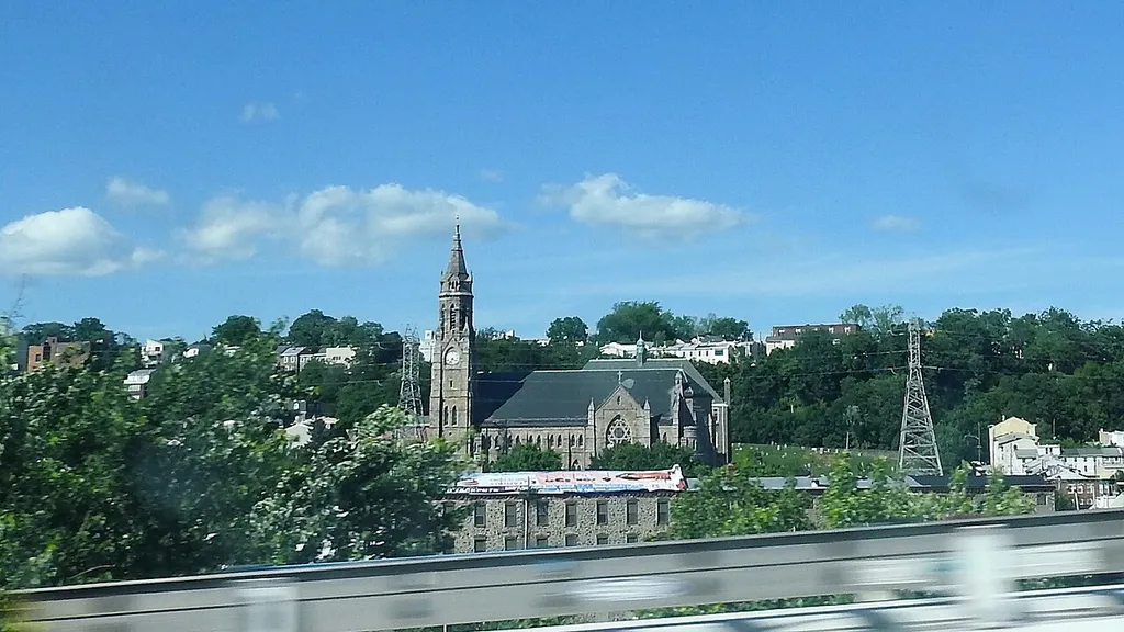 Looking northeast out the window of a passing bus, across the river.