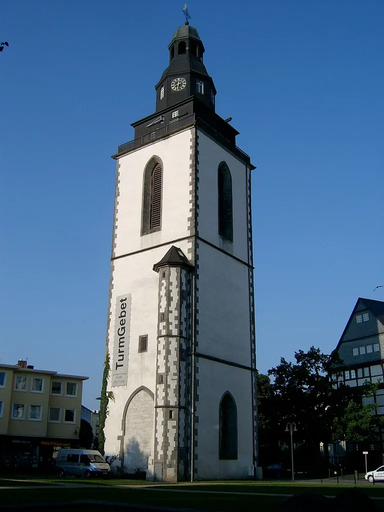 Der nach dem Zweiten Weltkrieg erhaltene dreigeschossige gotische Turm mit Helmaufbau der Stadtkirche in Gießen, Kirchenplatz 1.