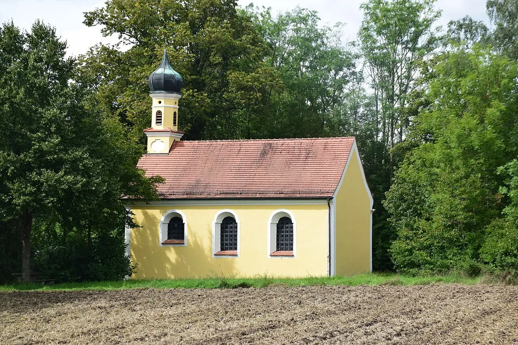 Saalkirche mit Steildach über rechteckigem Grundriss, mit Dachreiter und Sprenggiebelportal
