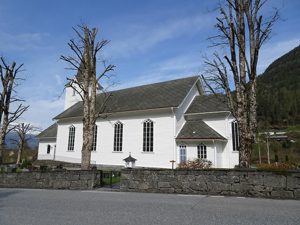 Jondal kirke med fylkesvei 105 i forgrunnen