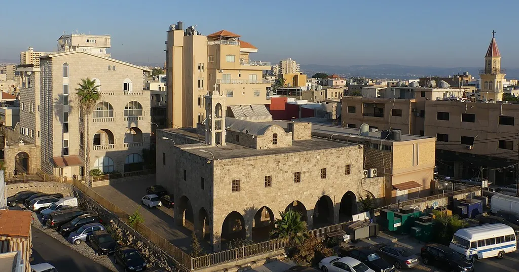 The Melkite Greek Catholic Cathedral of Saint Thomas in Tyre, South Lebanon, seen from the rooftop of the ĒL Boutique Hotel. On the left hand side of the church is the seat of the archeparchy. On the right hand side, the tower of the Franciscan church of Saint Anthony of Padua at the Convent of the Holy Land can be seen.