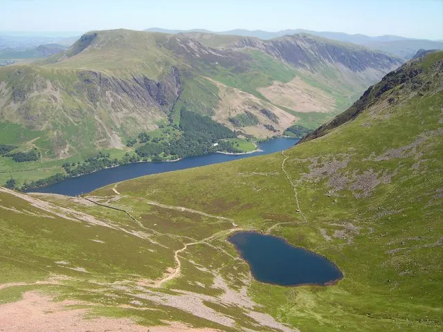 Bleaberry Tarn Classic corrie lochan. This tarn provides a good rest point on the ascent of Red Pike as well as being a destination for field trips. Some brave souls were swimming in it on this day. Robinson in the background, beyond Buttermere.