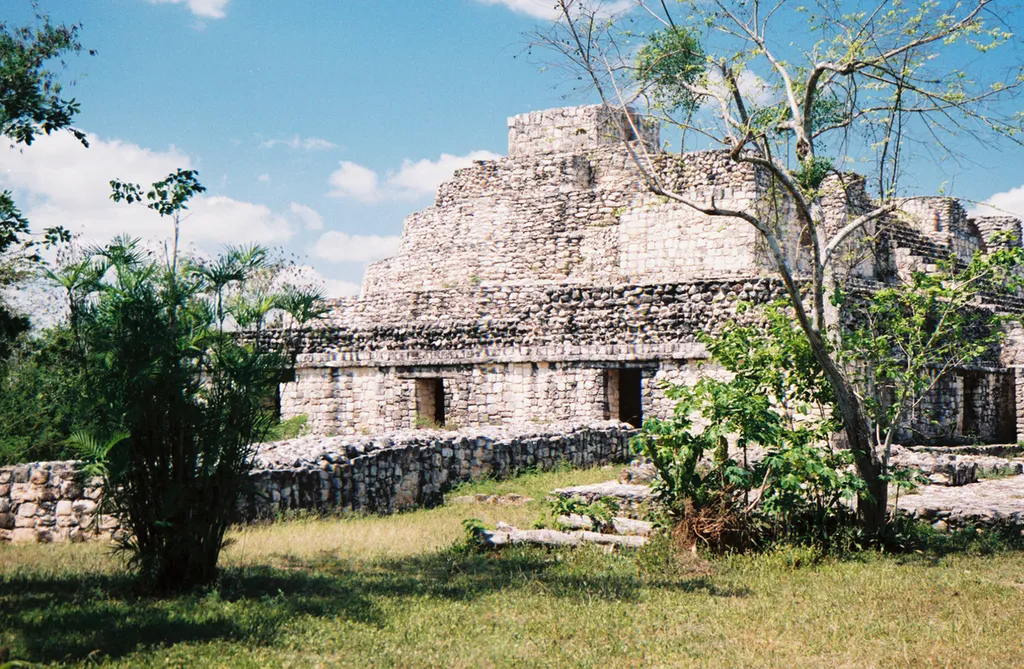 Taken by Dorothy Beals and Sarah Martin. Shows wall and 'Oval Palace' at Ek' Balam archaeological site.