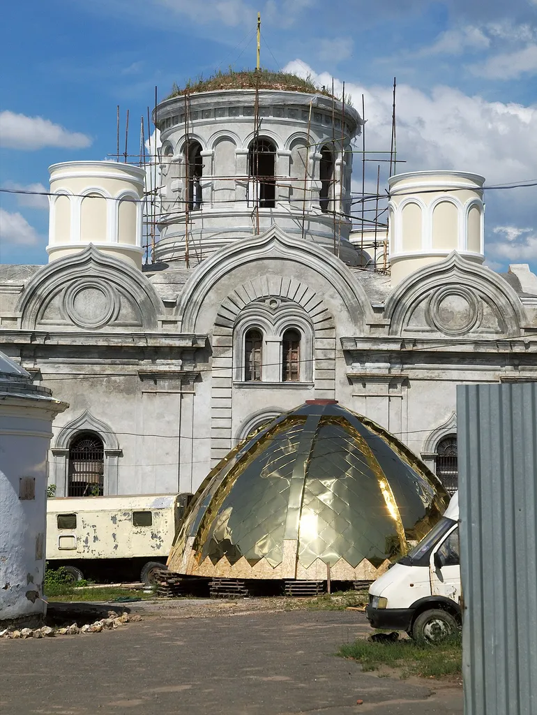 Reconstruction of the Transfiguration Cathedral at the Nikitsky Convent, Kashira. Lightweight dome shell, covered with oriented-strand board (and some temporary black plastic), was lying in the yard for two years. Then, in summer 2011, it was covered with "gilded" squares of what looks like anodized (??) stainless (??) steel.