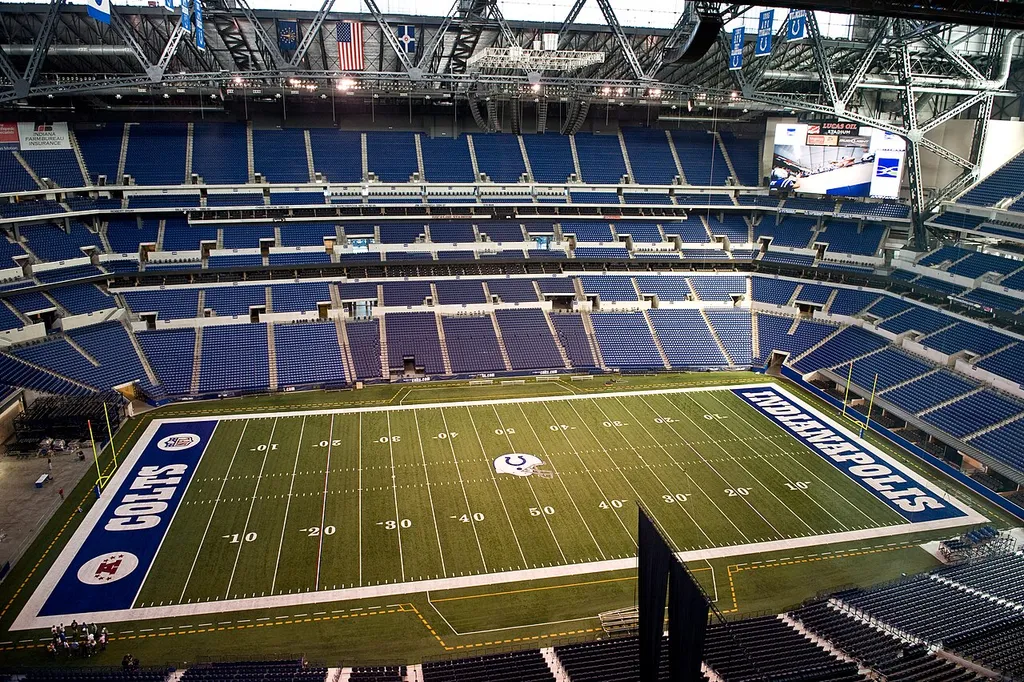 looking at the field at Lucas Oil Stadium. Lucas Oil Stadium is a multi-purpose stadium in Downtown Indianapolis, Indiana, United States. It replaced the RCA Dome as the home field of the NFL's Indianapolis Colts Indianapolis Indiana, opening on the 16th of August 2008. The stadium was constructed to allow the removal of the RCA Dome and expansion of the Indiana Convention Center on its site. The stadium is on the south side of South Street, a block south of the former site of the RCA Dome. In 2006, prior to the stadium's construction, Lucas Oil Products secured the naming rights for the stadium at a cost of $122 million over 20 years. The architectural firm HKS, Inc. was responsible for the stadium's design, with Walter P Moore working as the Structural Engineer of Record. The stadium features a retractable roof and a large retractable window on one end, thus allowing the Colts and the Eleven to play both indoors and outdoors. The field surface was originally FieldTurf but was replaced in 2018 with Shaw Sports Momentum Pro. The exterior of the new stadium is faced with a reddish-brown brick trimmed with Indiana limestone, similar to several other sports venues in the area, including Bankers Life Fieldhouse, Hinkle Fieldhouse, and the Fairgrounds Coliseum.