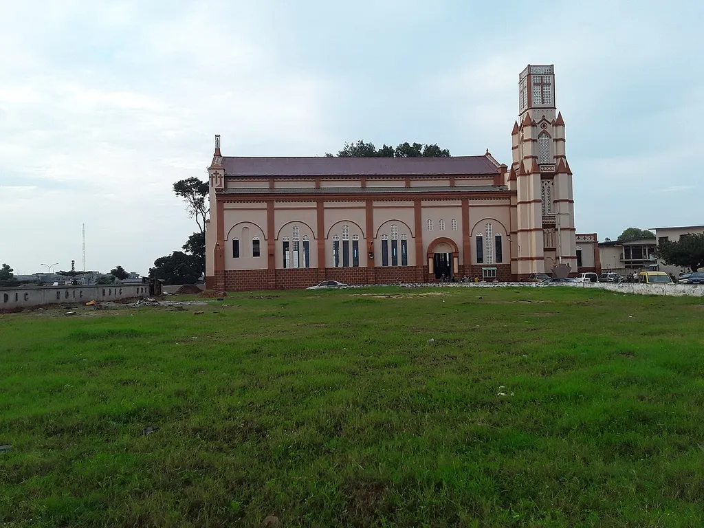 Cathédrale Notre Dame de l'Immaculée Conception Porto-Novo Située à l’entrée de la ville et en bordure de la lagune de Porto - Novo, la Paroisse Cathédrale reste la plus belle Eglise de la ville de par son architecture et aussi à cause de l’opportunité d’accueil offerte à tout voyageur provenant de Cotonou. Constituée de plus de vingt cinq (25) quartiers, la Paroisse Cathédrale, reste le cœur politique de la ville - capitale politique du Bénin et siège de hautes institutions politiques – juridiques – militaires et paramilitaires. Elle n’a toutefois pas l’exclusivité absolue de religiosité. Toutes les grandes religions et cultes du Bénin y sont représentés, prédisposant alors la Paroisse Cathédrale à de nombreux défis d’évangélisation dont le défi d’inculturation - le défi de dialogue interreligieux pour la construction d’une société de justice et de paix où la dignité humaine - la liberté religieuse - et le bien commun sont respectés et promus. Érigée en 1864, la cathédrale depuis 2014 est en jubilé des 150 ans de son évangélisation.
