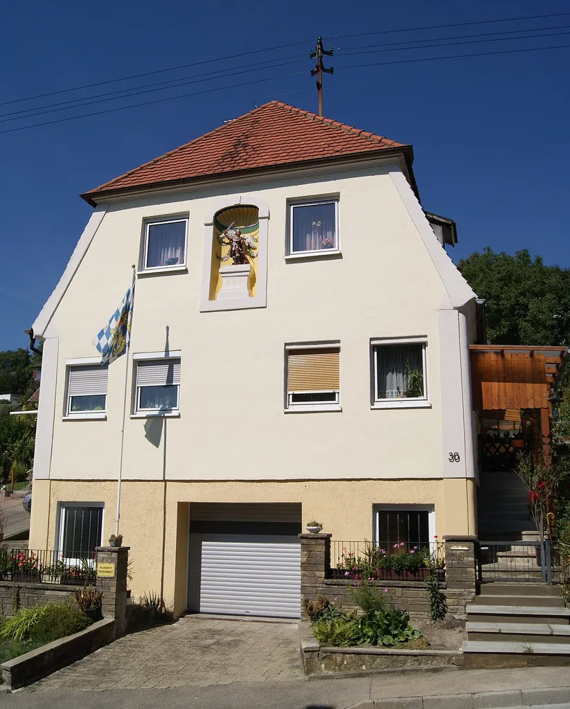 Oberelchingen, Klostersteige 30, Ehem. Klosterrichterhaus, giebelseitig mit Halbwalmdach, Rückseite Vollwalmdach, 2. Hälfte 18. Jahrhundert; klassizistische Hausfigur St. Michael.